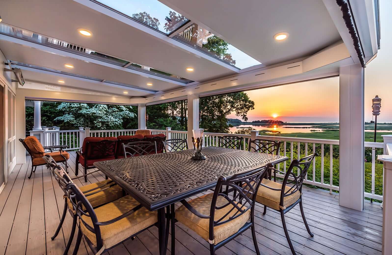 Outdoor liferoom with dining area and sunset view.