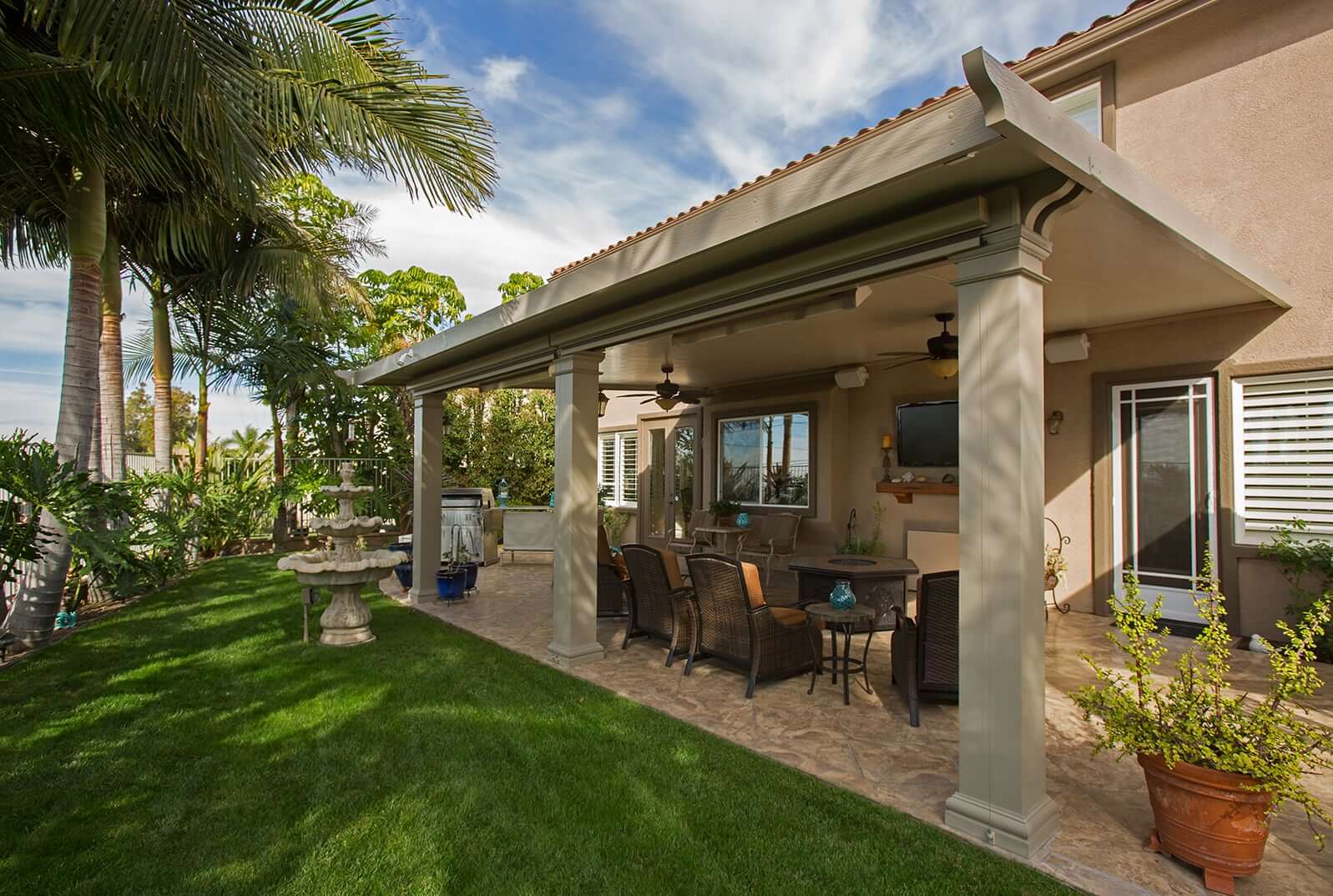 A patio with outdoor furniture and a green lawn
